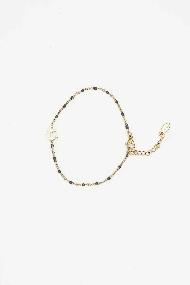 Pulsera o brazalete color dorado con ancla, piedra azul.